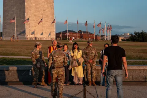 Getty Images Troops were seen posing with tourists on the National Mall near the Washington Monument