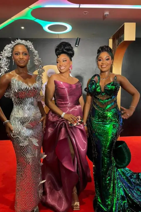 BBC/CHIMEZIE UCHEAGBO Three women pose in their dresses.