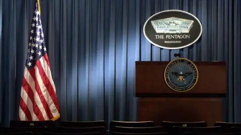 Getty Images Pentagon press room with empty podium under Pentagon sign next to American flag