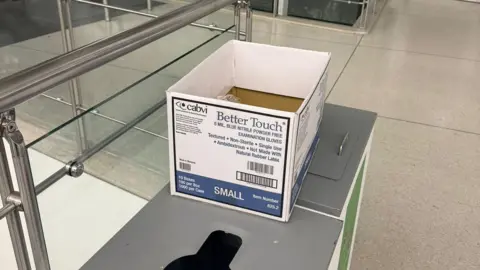 Pavel Talankin A white box with blue writing sits on a table in an airport 
