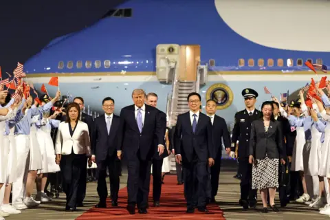 Getty Images U.S. President Donald Trump (C) is joined by Chinese Executive Vice Minister of Foreign Affairs Ma Zhaoxu, U.S. Ambassador to China David Perdue, Vice President of China Han Zheng and Chinese Ambassador to the U.S. Xie Feng as he arrives at Beijing Capital International Airport on May 13, 2026 in Beijing, China. 