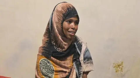 Hiwot Fana Specialised Hospital Close-up of Bedriya smiling. She is wearing a patterned printed green and yellow head covering.