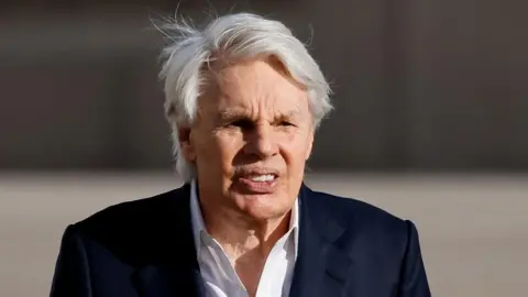Reuters An older man with white hair wears a black suit jacket and a white shirt