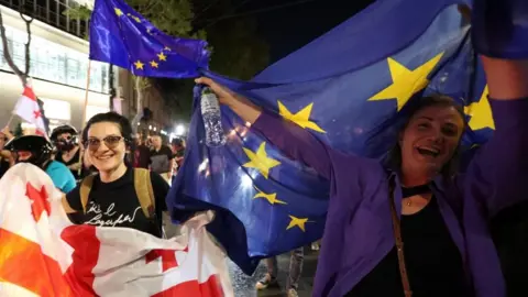 Reuters Demonstrators carry flags of Georgia an the European Union during a protest against a bill on "foreign agents" in Tbilisi, Georgia April 28, 2024.