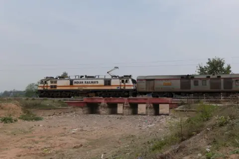 Bloomberg via Getty Images A train passes over a bridge over a dried canal in Banda district of Uttar Pradesh, India, on Monday, Feb. 26, 2024. 