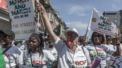 AFP via Getty Images March on March protesters are seen leading a protest against illegal immigration in South Africa