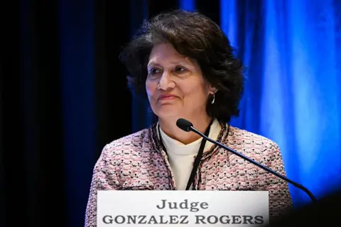 Getty Images Judge Gonzalez Rogers appears on a panel wearing a tweed jacket and white turtleneck