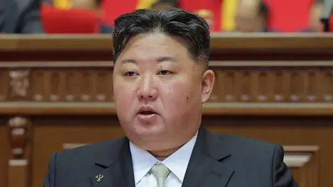AFP PHOTO/KCNA VIA KNS Kim Jong Un wearing a black suit and light green tie