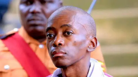 Amon Ngabo / BBC Christopher Okello Onyum stares into the distance, his face is expressionless.