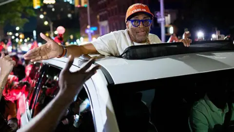 Getty Images Spike Lee is driven through a crowd of New York Knicks supporters 