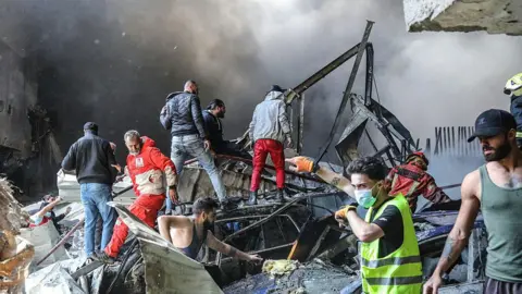 AFP via Getty Images Rescuers clear rubble in Beirut