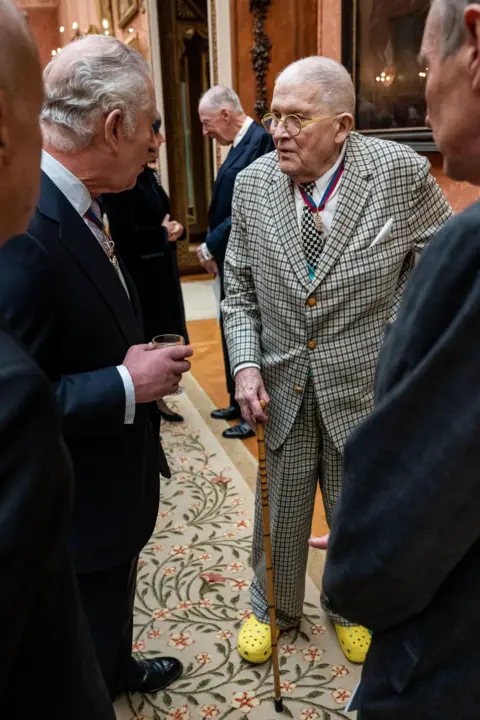 Getty Images Charles and Hockney speaking, with Hockney in bright yellow Crocs
