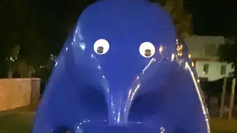 Facebook/Amelia Vanderhorst Large blue animal sculpture with a long nose and two googly eyes