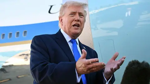 Getty Images US President Donald Trump wears a navy suit and blue tie as he speaks to reporters before boarding Air Force One.