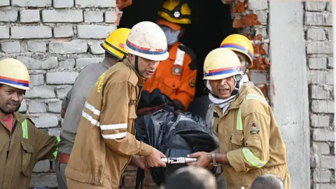 Getty Images Firefighters and State Disaster Response Force teams recover the bodies of victims after a massive fire broke out inside a three-floor commercial building.