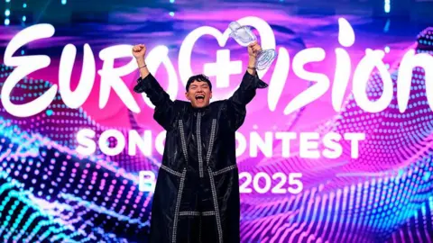 Getty Images Eurovision 2025 winner JJ raises a clear trophy 
