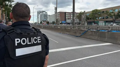 Getty Images Back of officer in black vest marked with white letters reading 