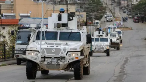Reuters White UNIFIL vehicles drive on a main road in Qlayaa, amid escalating hostilities between Israel and Hezbollah