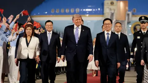 Reuters Trump walks along tarmac from Air Force One in Beijing on Wednesday evening