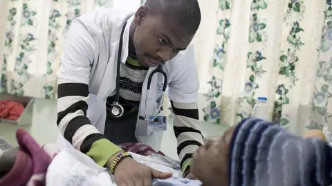 Getty Medical student Lwando Mpotulo (c), age 23, examines a patient in a ward at GF Jooste hospital on October 21, 2010, Cape Town, South Africa