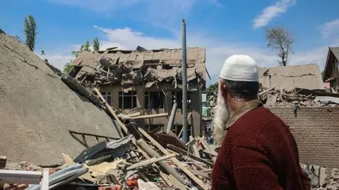 AFP via Getty Images A man stands near the debris of a demolished house related to the family of Ahsan Ul Haq Sheikh, a militant who officials say is involved in the deadly attack on tourists in Pahalgam, at Murran village in Pulwama, south of Srinagar, Jammu And Kashmir, on April 26, 2025