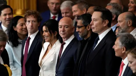 Reuters Appearing at the second inauguration of Donald Trump, from left to right: Mark Zuckerberg in a black suit, white dress shirt and red necktie; Jeff Bezos in a navy suit, white dress shirt and red neck tie; Sundar Pichai in an all black suit, shirt and neck tie; Elon Musk in a black suit, white dress shirt and navy neck tie
