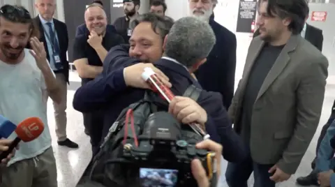 Reuters Italian lawmaker Dario Carotenuto is embraced by a relative 