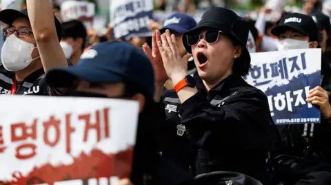 Bloomberg via Getty Images Samsung Electronics Co. workers chant slogans during a rally outside the company's semiconductor plant in Pyeongtaek, South Korea, on Thursday, 23 April, 2026.