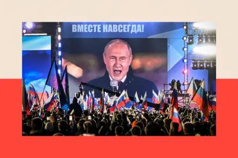 AFP via Getty Images Russian President Vladimir Putin is seen on a screen set at Red Square as he addresses a rally 