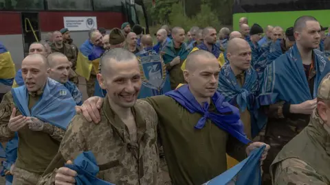 AFP via Getty Images Released Ukrainian prisoners of war (POWs) react following a prisoner exchange at an undisclosed location