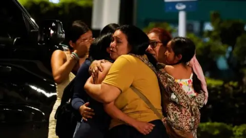 REUTERS/Cesar Munoz A group of women is seen crying and hugging outside José Joaquín de Olmedo International Airport after a man was shot dead and another injured on 17 June , 2026.