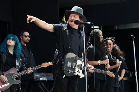 Getty Images Eddie Vedder points onstage while he performs with Guitars Over Guns during the dedication ceremony.