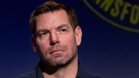 Getty Images Eric Swalwell wears a dark blue button down shirt at a candidate forum in Los Angeles last year.