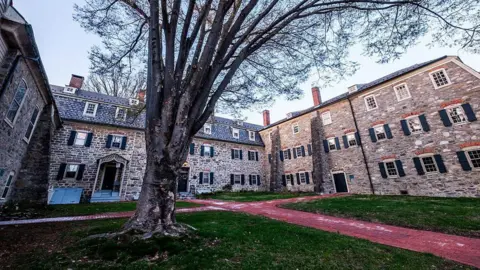 Getty Images A large old brick building surrounds a green court yard