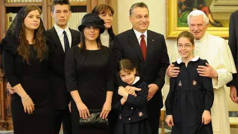 ALBERTO PIZZOLI/AFP via Getty Images Pope Benedict XVI (R) poses with Hungary's Prime Minister Viktor Orban (2D-L), his wife Aniko Levai (3D-L), and their five children during a private audience at The Vatican on December 6, 2010