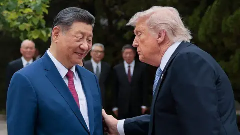 Getty Images Trump holding Xi's arm during his visit to Beijing.