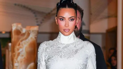 Getty Images US reality star Kim Kardashian in a white dress with long sleeves and turtle neck.