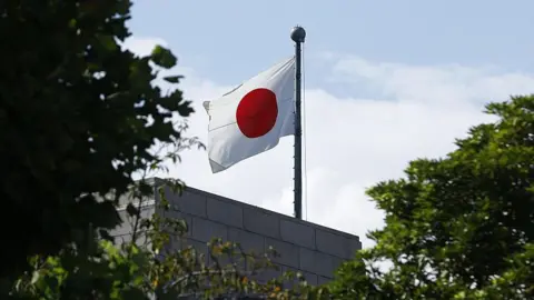 Getty Images A Japanese flag is visible through trees