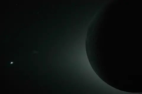 NASA Dark outline of the Moon with the glow of the Sun from behind and Venus as a bright spot in the bottom left hand corner