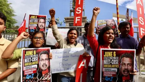 EPA-Shutterstock Members of the All India Students Federation hold placards and shout slogans during a protest against the alleged exam paper leak in Bangalore, India, on 06 June 2026.