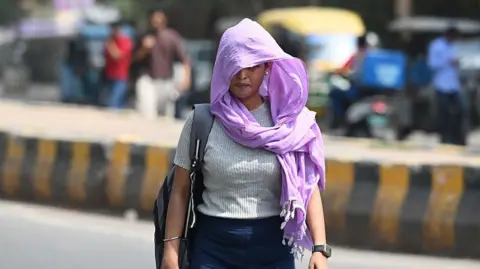 Getty Images A woman in Delhi covers her head with a cloth to protect herself from the sun