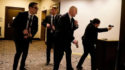 Getty Images Four armed officers point pistols