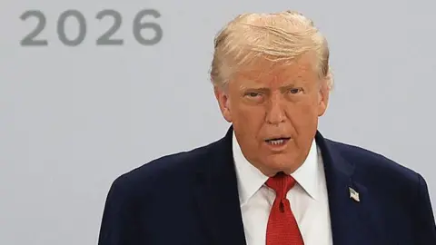 Getty Images Trump speaks wearing a suit at the G7 