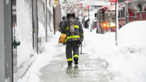 Getty Images A firefighter walks through the winter storm