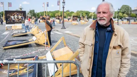 CHRISTOPHE PETIT TESSON/EPA/Shutterstock French photographer Yann Arthus-Bertrand looks at his damaged artworks at his exhibition 'Vivre Ensemble