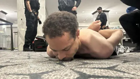 @REALDONALD TRUMP / TRUTHSOCIAL A photo appearing to show the suspected gunman on the floor of the Washington Hilton hotel