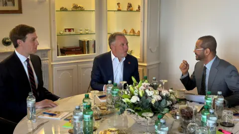 Oman Ministry of Foreign Affairs/Handout via REUTERS Jared Kushner (L) and Steve Witkoff (C) speak to Omani Foreign Minister Badr Albusaidi ahead of indirect talks with Iran in Geneva, Switzerland (17 February 2026)
