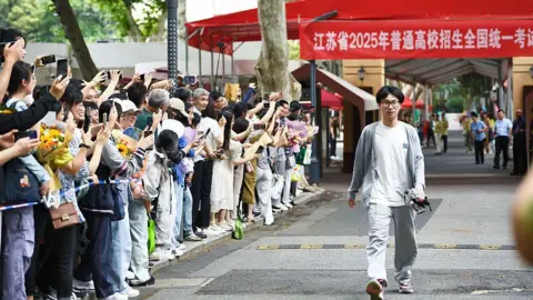 Costfoto/NurPhoto via Getty Images Parents line the streets to welcome the students taking the college entrance examination out of the examination room in Nanjing, Jiangsu Province