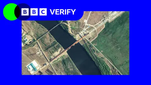 BBC An annotated satellite image taken on 6 May showing the new road bridge and the existing rail bridge. It is imposed over the BBC Verify colours and branding.