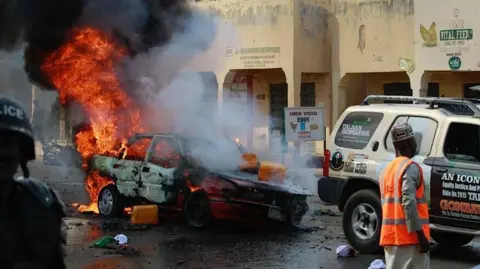 Anadolu via Getty Images A car on fire after bombing in Nigeria's north eastern Gombe state in 2015